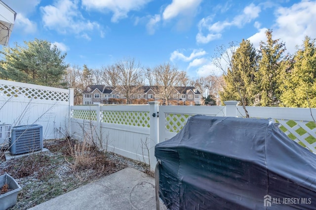 view of patio / terrace with central AC unit, a fenced backyard, grilling area, and a residential view