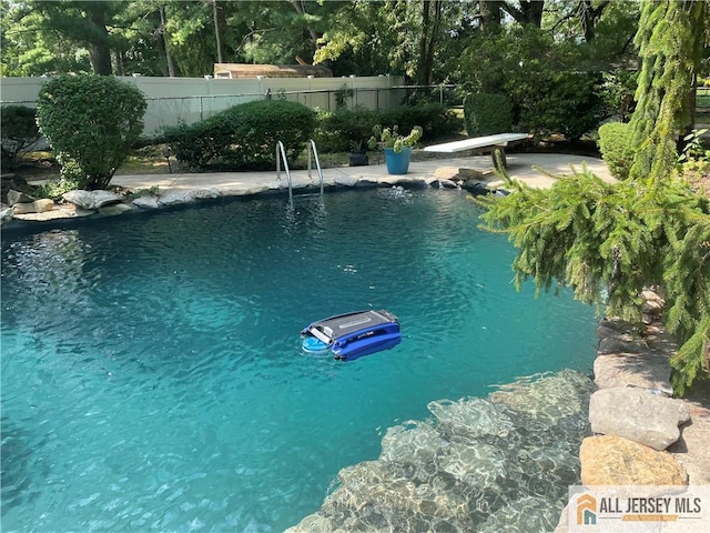 view of pool featuring a diving board