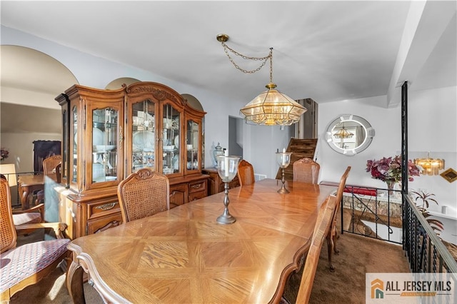 carpeted dining space with a notable chandelier