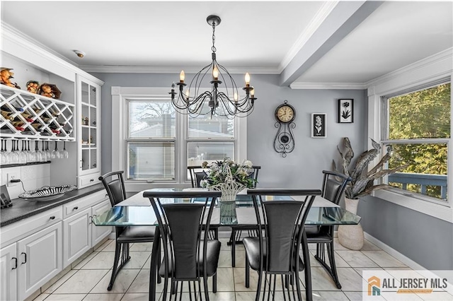 tiled dining room with ornamental molding and a chandelier