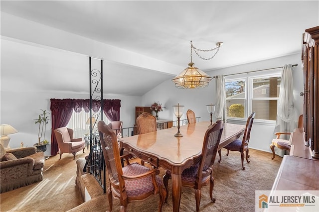 carpeted dining space with lofted ceiling