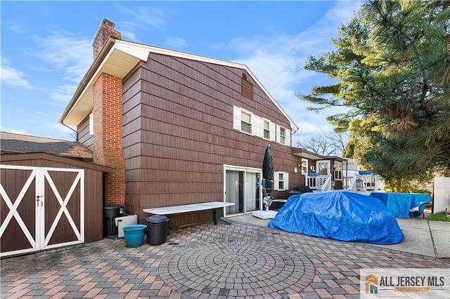 back of house featuring a patio area and a storage shed