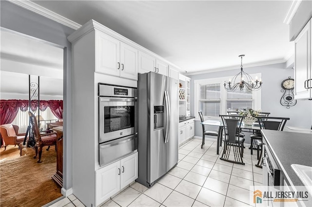 kitchen with crown molding, an inviting chandelier, white cabinets, and appliances with stainless steel finishes