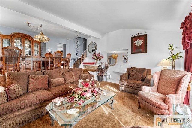 living room featuring carpet flooring, lofted ceiling with beams, and a notable chandelier