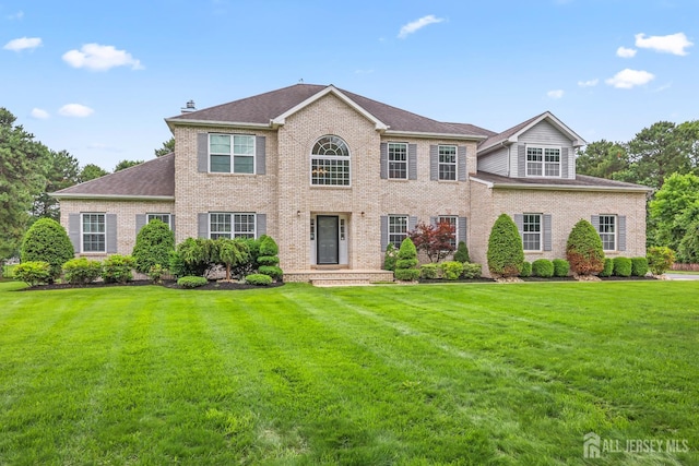 1004 Antoinette Dr, Monroe, NJ 08831 - colonial home with brick siding, a front yard, a chimney, and roof with shingles