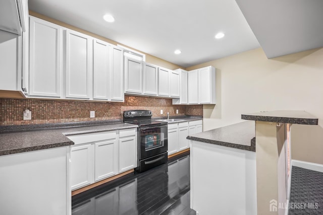 1004 Antoinette Dr, Monroe, NJ 08831 - kitchen with black electric range, dark countertops, tasteful backsplash, white cabinets, and recessed lighting