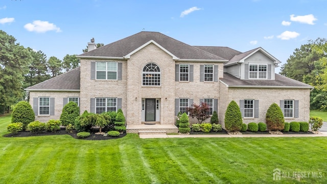 1004 Antoinette Dr, Monroe, NJ 08831 - colonial inspired home with a chimney, a front lawn, brick siding, and roof with shingles