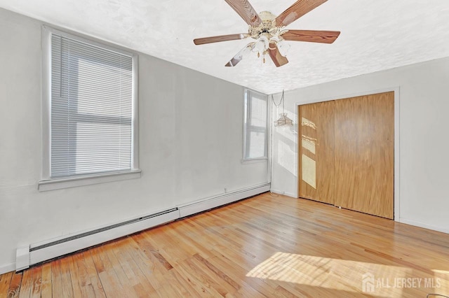 unfurnished bedroom with a textured ceiling, ceiling fan, a closet, and a baseboard radiator