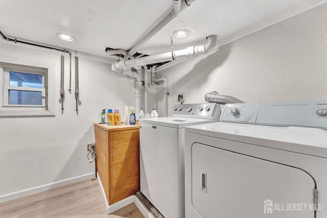 clothes washing area featuring light wood-type flooring and independent washer and dryer