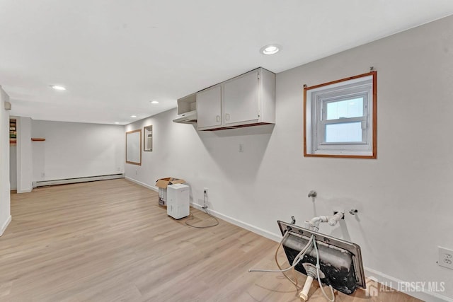 interior space featuring baseboard heating and light hardwood / wood-style floors