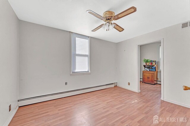 unfurnished room with ceiling fan, baseboard heating, and light wood-type flooring