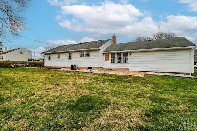 rear view of house featuring a lawn and a patio area