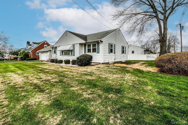 view of side of property with a yard and a garage