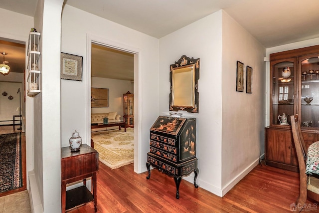 hallway featuring a baseboard heating unit and dark hardwood / wood-style floors