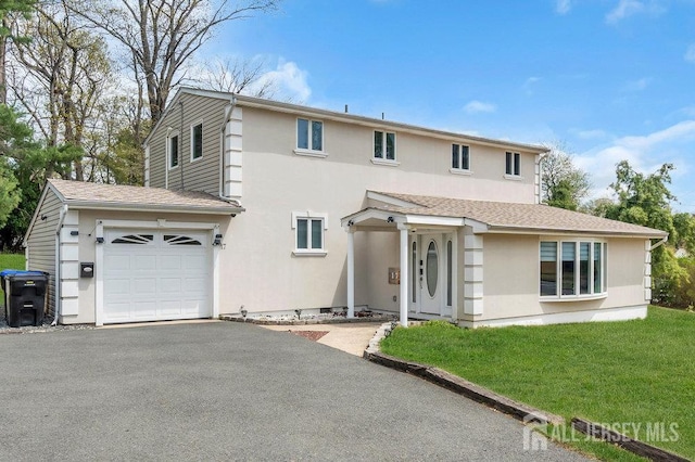 17 Thomas Rd, East Brunswick, NJ 08816 - traditional-style house with stucco siding, asphalt driveway, a front lawn, and a garage