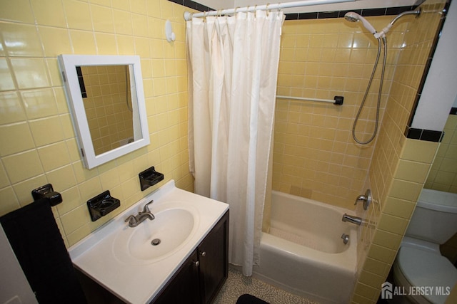 full bathroom with vanity, toilet, tile walls, and shower / bath combo with shower curtain