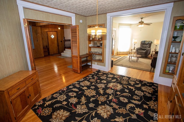 corridor with an inviting chandelier and light hardwood / wood-style flooring