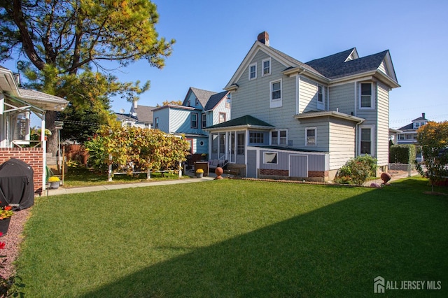 rear view of property with a yard