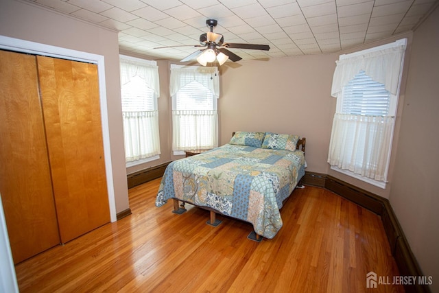 bedroom featuring hardwood / wood-style floors, ceiling fan, and baseboard heating