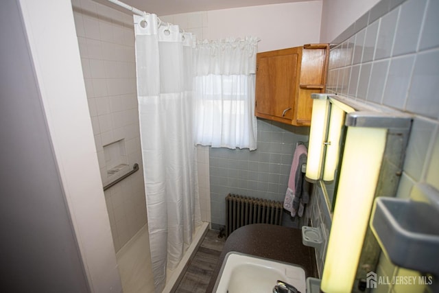 bathroom with radiator heating unit, curtained shower, and tile walls