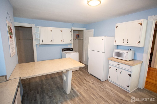 kitchen with white cabinetry, washer / dryer, white appliances, and light wood-type flooring