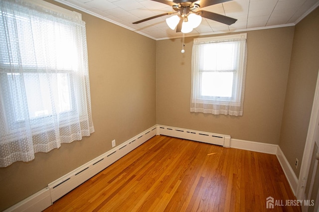 unfurnished room with hardwood / wood-style floors, baseboard heating, ornamental molding, and ceiling fan