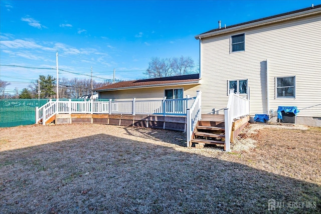 rear view of property featuring a wooden deck and fence