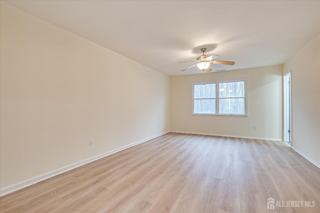 spare room featuring a wealth of natural light, light wood-style flooring, and baseboards