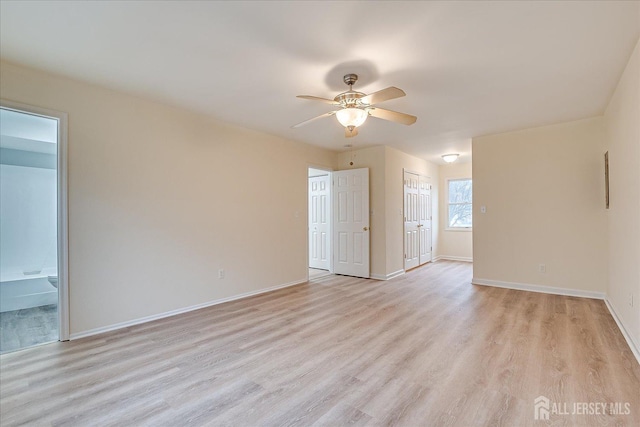 unfurnished room with light wood-type flooring, baseboards, and a ceiling fan