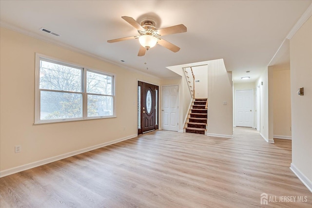 unfurnished living room with light wood finished floors, visible vents, baseboards, stairway, and ornamental molding