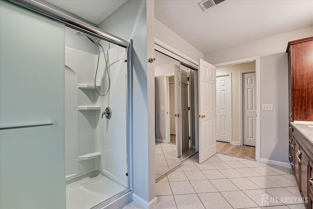 full bath featuring visible vents, baseboards, a shower stall, and tile patterned flooring