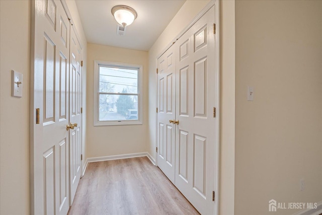 doorway to outside with visible vents, baseboards, and light wood-style floors