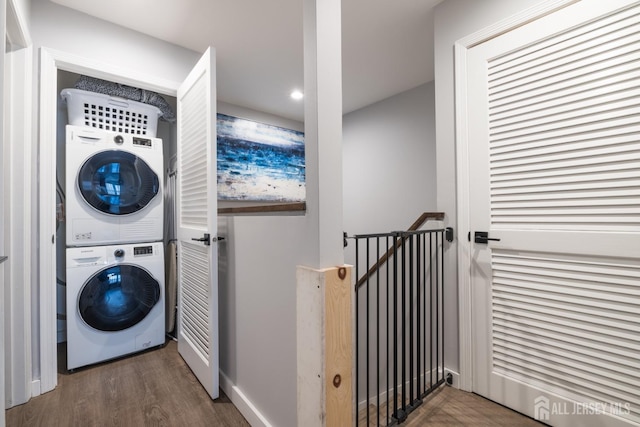 laundry room with stacked washer and clothes dryer and dark wood-type flooring