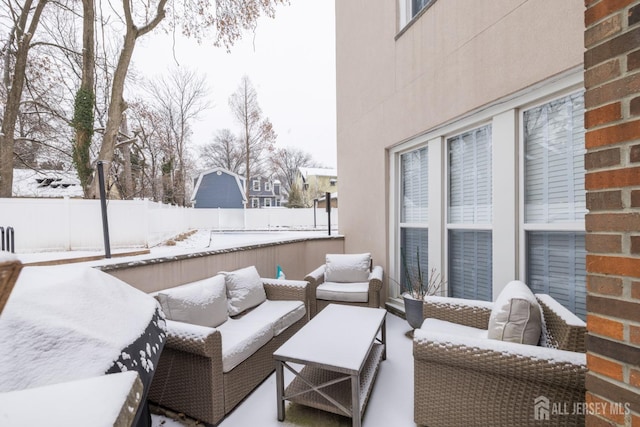 snow covered patio with an outdoor living space