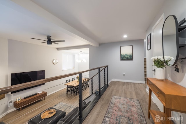 hallway featuring light hardwood / wood-style floors, beamed ceiling, and an inviting chandelier