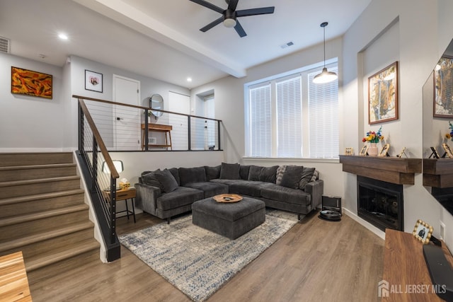 living room featuring ceiling fan, beamed ceiling, and hardwood / wood-style floors