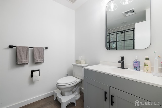 bathroom featuring vanity, toilet, and hardwood / wood-style flooring