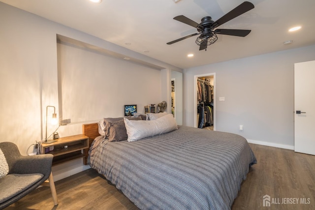 bedroom featuring ceiling fan, dark hardwood / wood-style floors, a closet, and a spacious closet