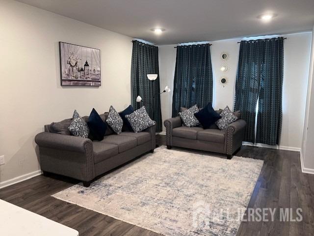 living area with dark wood-style floors and baseboards