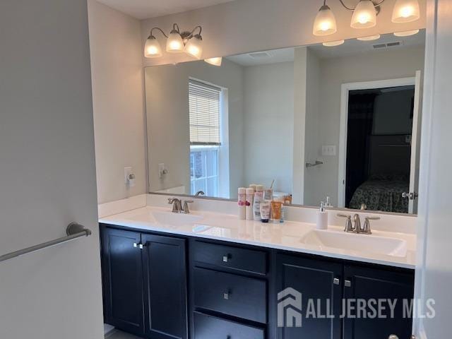 ensuite bathroom with a sink, ensuite bath, and double vanity