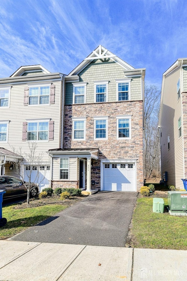 view of front facade featuring aphalt driveway, an attached garage, and stone siding