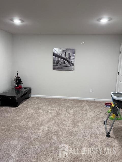 recreation room with baseboards and carpet flooring