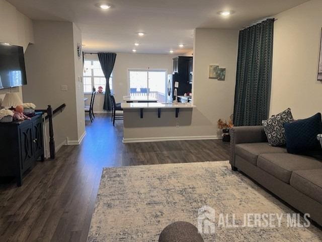 living area with recessed lighting, dark wood-style floors, and baseboards