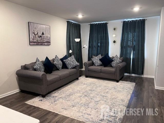 living room with baseboards and dark wood finished floors