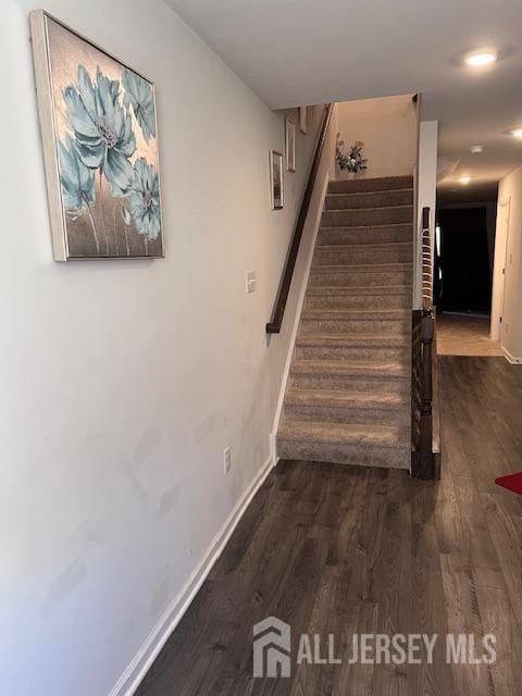 stairway featuring baseboards and wood finished floors