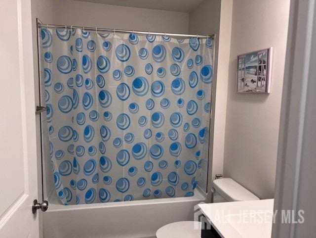 bathroom featuring vanity, toilet, and shower / bath combo with shower curtain