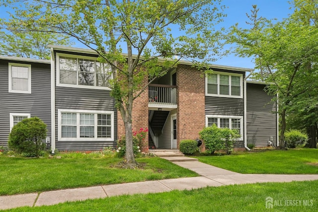 78 Pennsylvania Way N, Brunswick, NJ 08902 - view of front facade featuring a balcony, a front yard, and brick siding