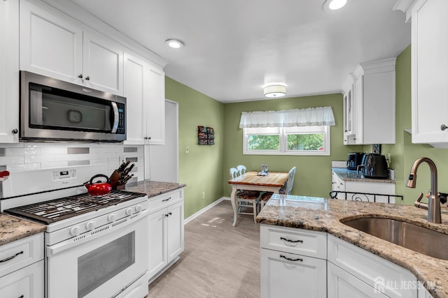 6 Onondaga St, Old Bridge, NJ 08857 - kitchen with stainless steel microwave, white range with gas stovetop, a sink, white cabinetry, and baseboards