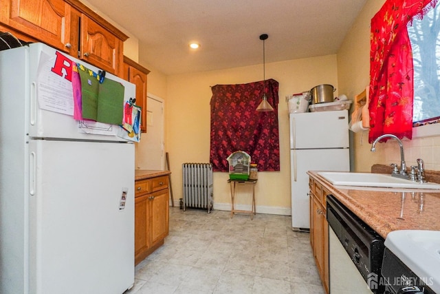 kitchen with white appliances, radiator, decorative light fixtures, light countertops, and a sink