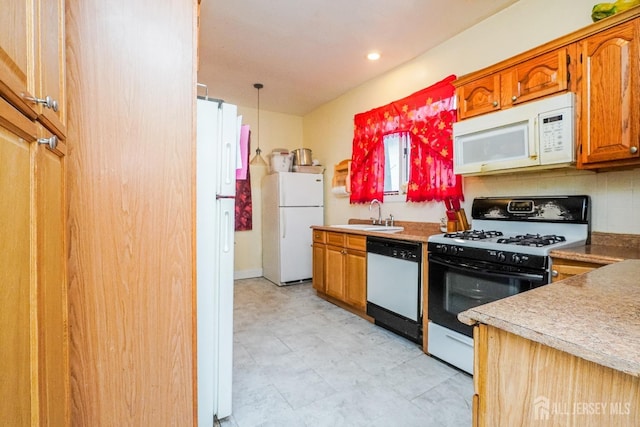 kitchen with light countertops, white appliances, brown cabinets, and a sink